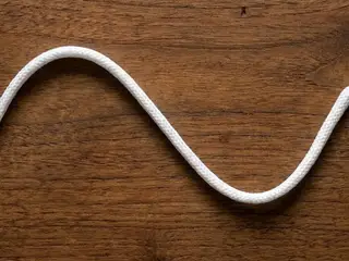Ilustração de um cordão branco, representando a alça de papel torcido.