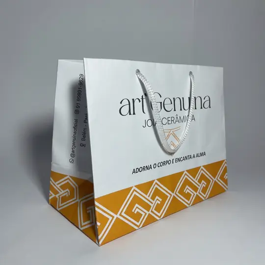 Sacola de papel branca com faixa estampada em dourado na parte de baixo e alça branca